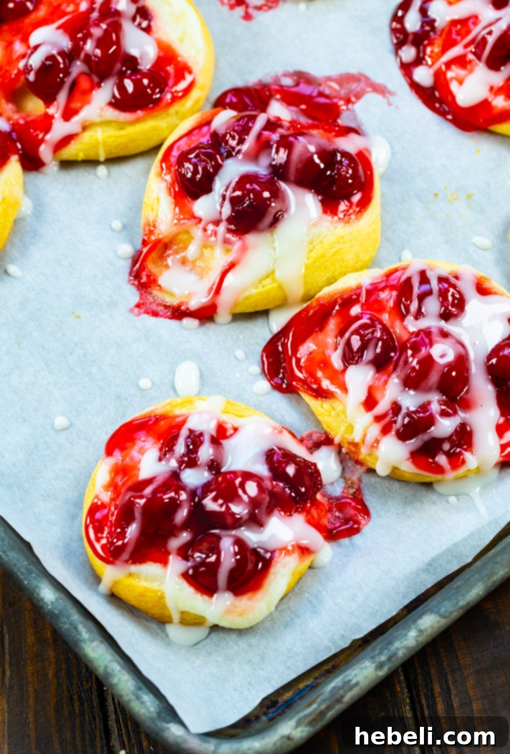 Flaky Cherry Danishes Made Simple 4 A tray of freshly baked Easy Cherry Danishes, glistening with glaze, cooling on a baking sheet.
