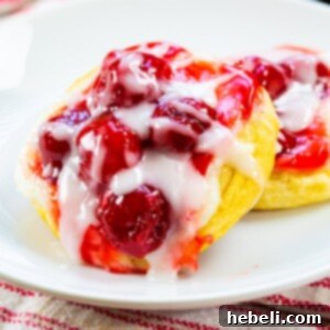 Two Cherry Danishes on a plate.