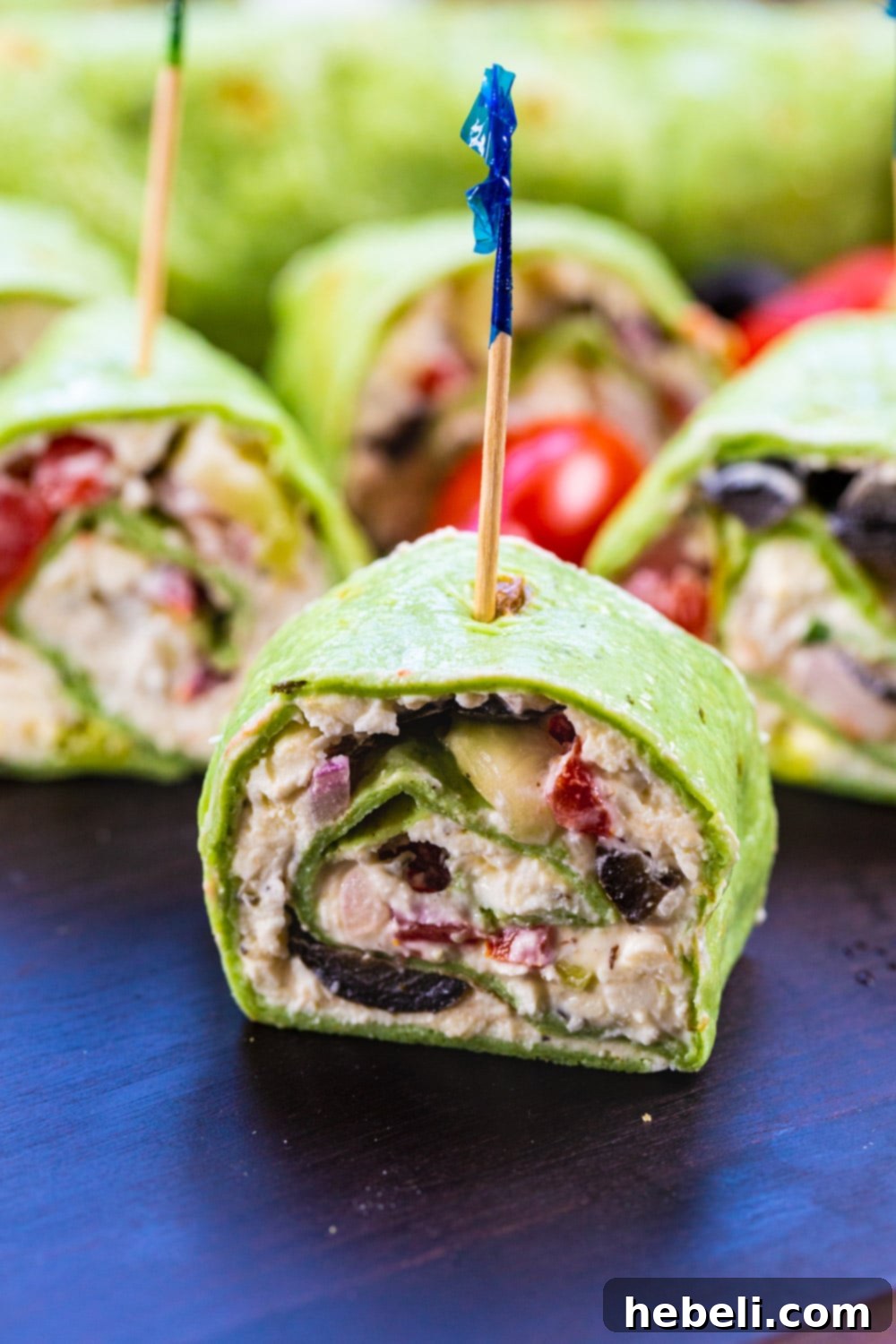 Mediterranean Swirl Appetizers 3 A close-up of colorful Greek Salad Pinwheels, skewered with toothpicks for easy serving, presented as a fantastic vegetarian party appetizer.