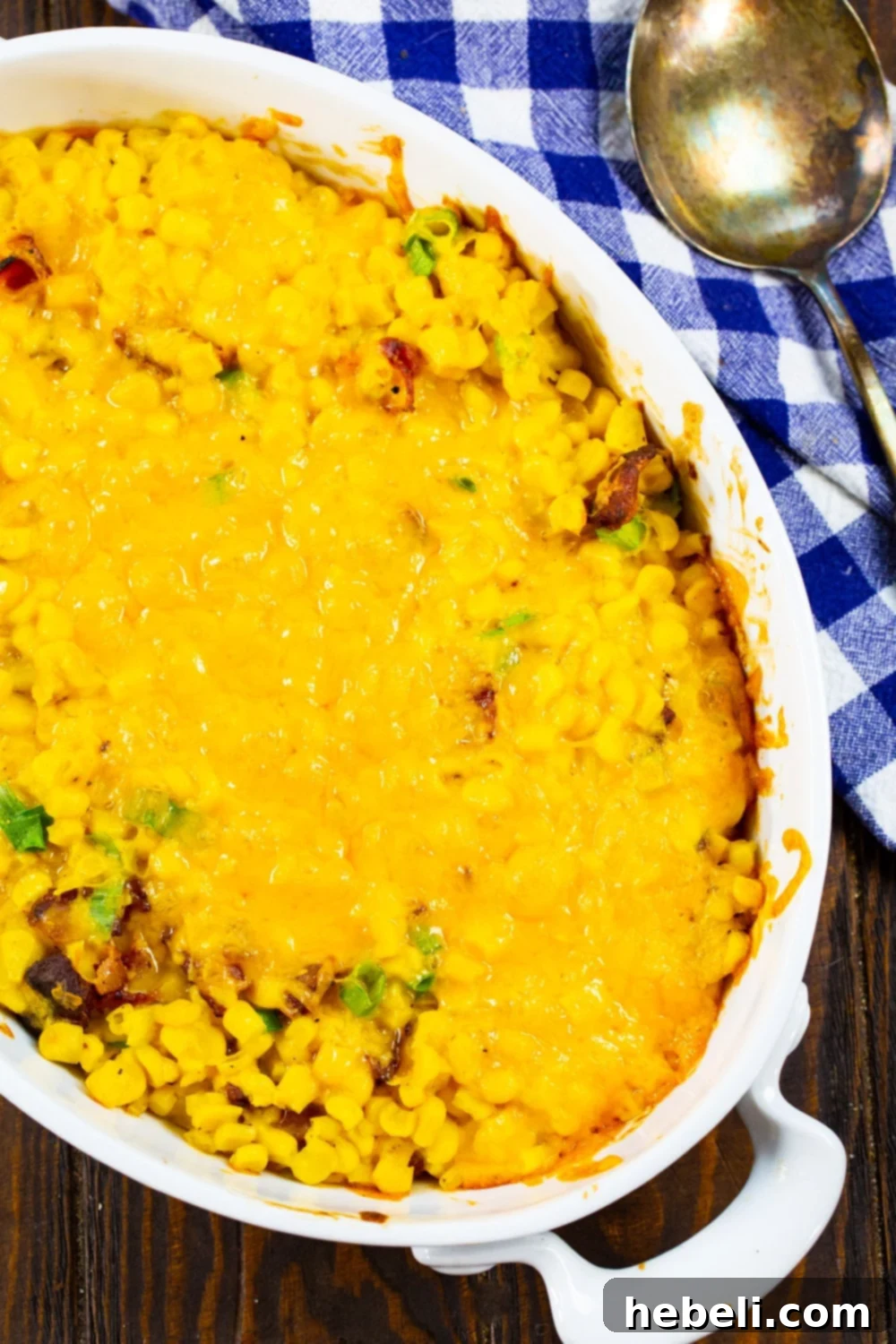 Close-up of baked Cheesy Corn Casserole with bacon, showcasing the golden-brown crust and creamy interior.