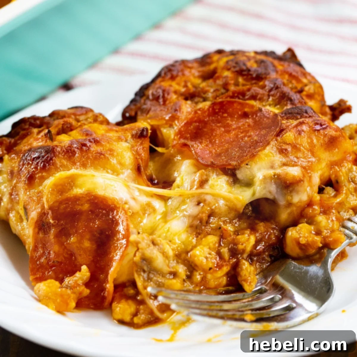 A delectable slice of Meat Lovers Bubble Up Pizza, perfectly browned and cheesy, resting on a white plate ready to be enjoyed.