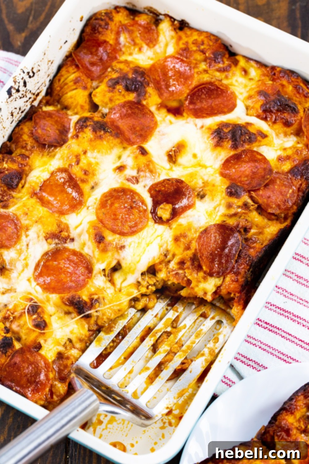 The finished Meat Lovers Bubble Up Pizza in its baking dish, golden brown and bubbling, ready to be portioned and served.