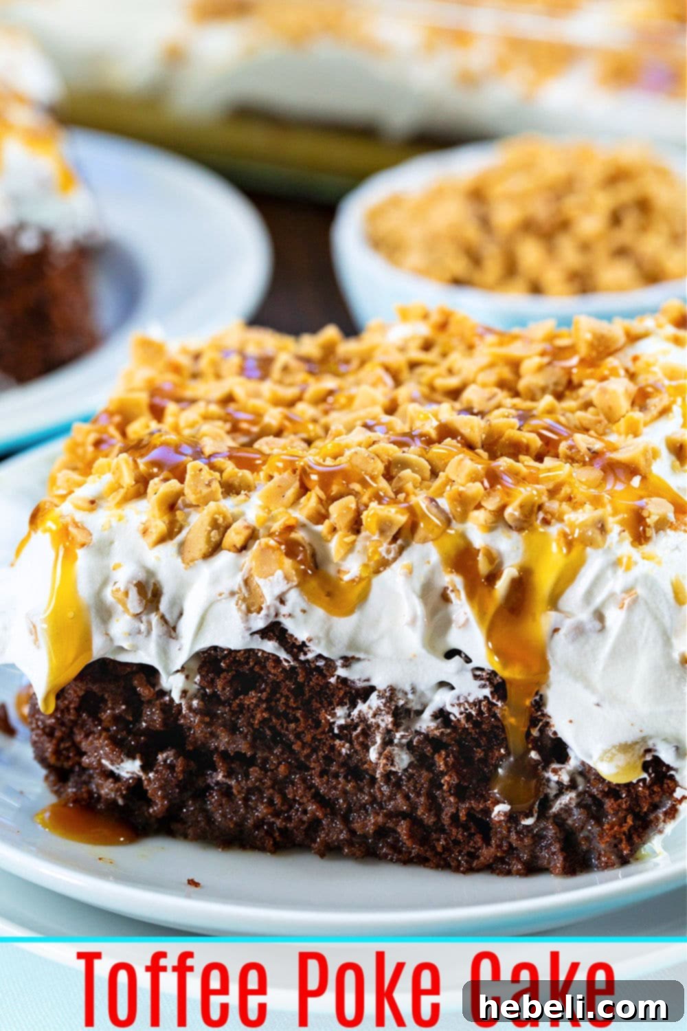 A beautifully presented whole Toffee Poke Cake, topped with whipped cream and a generous sprinkling of toffee bits, ready to be sliced.