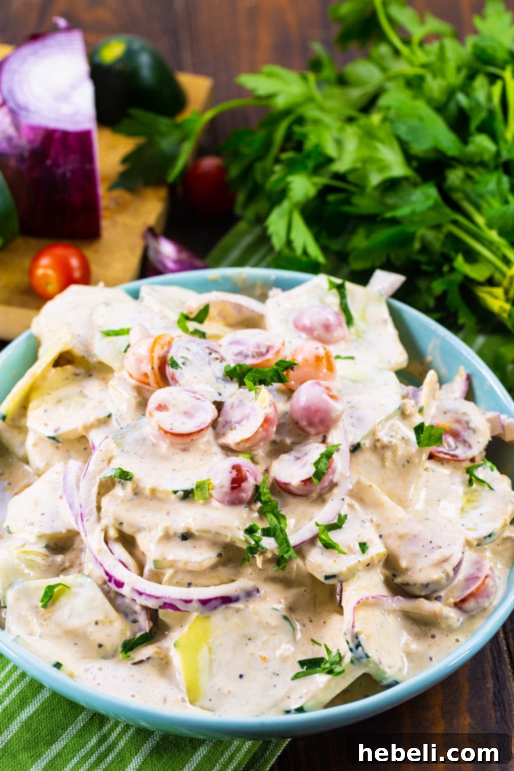 Tuscan Creamed Cucumber Salad 4 Creamy Italian Cucumber Salad in bowl with bunch of fresh parsley in background.