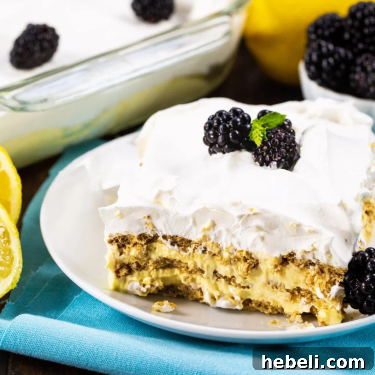 Zesty Lemon Icebox Cake 2 A beautiful slice of Lemon Icebox Cake garnished with fresh blackberries, showcasing its distinct layers.