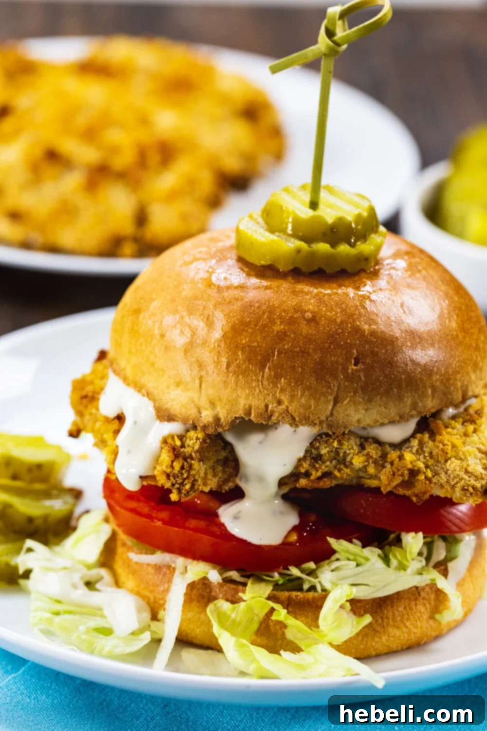 Close-up of Cornflake Crusted Chicken Sandwich with ranch dressing drippinf down.