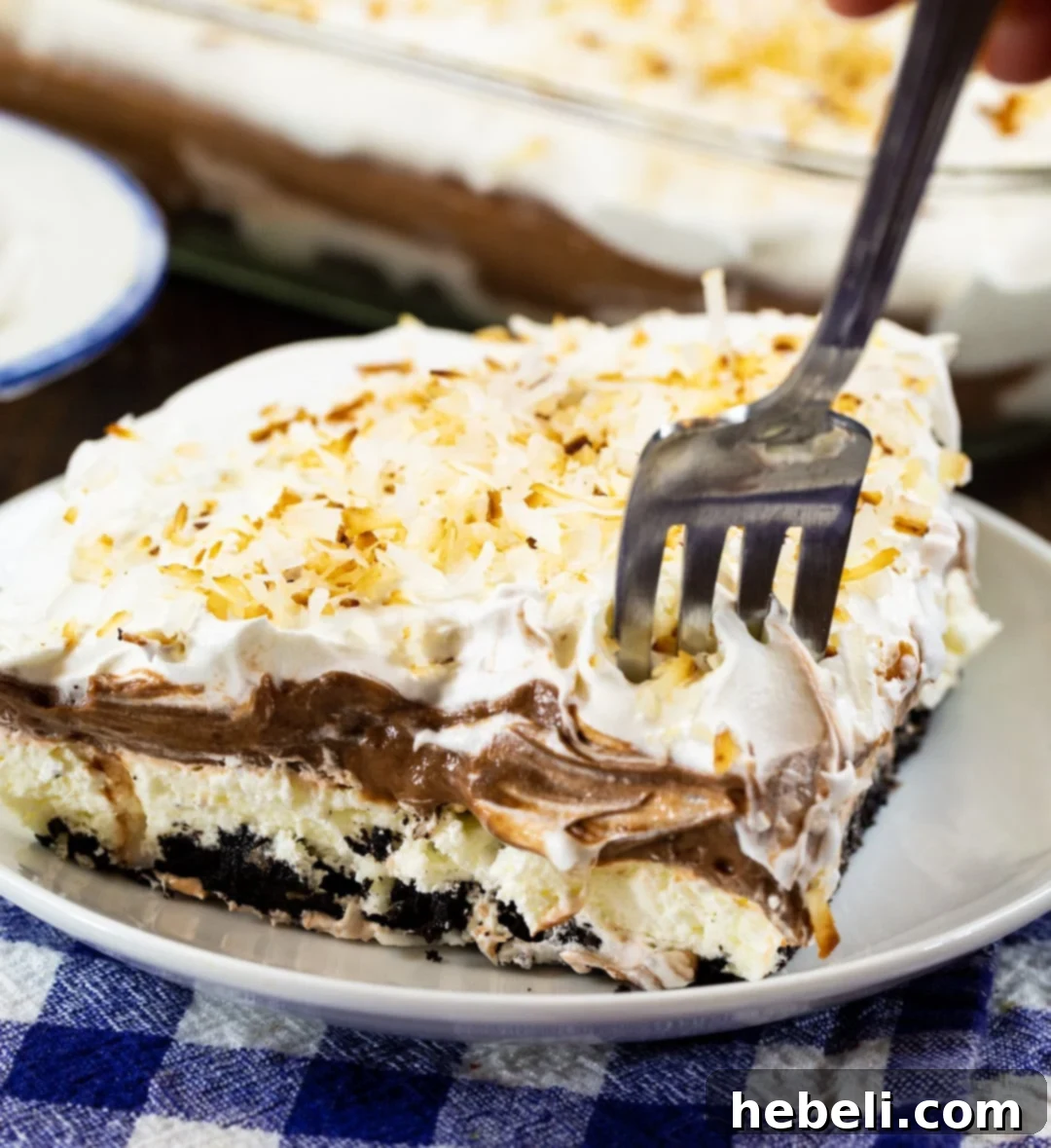 Velvet Chocolate Coconut Heaven 4 Fork being stuck in slice of Chocolate Coconut Lush.