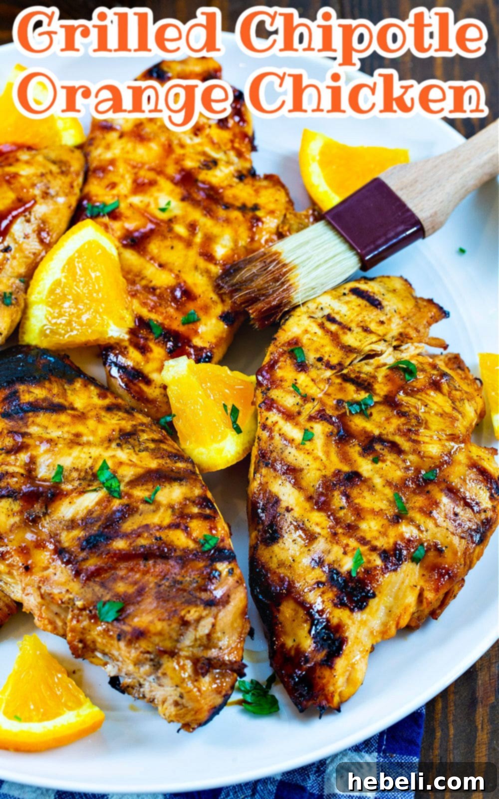 Flame Kissed Chipotle Orange Chicken 4 Close-up of a perfectly cooked Grilled Chipotle Orange Chicken on a serving plate, showcasing its beautiful char and glistening glaze, garnished with fresh herbs.