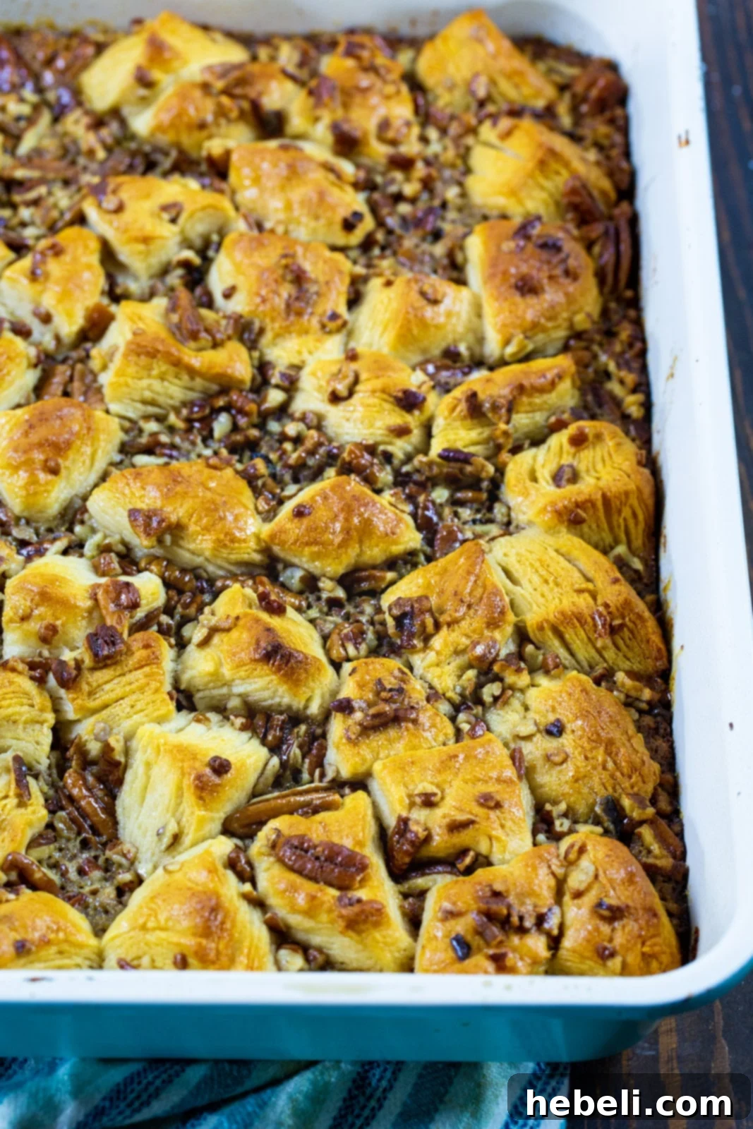Pecan Pie Bubble Up baking in a glass dish, showing the golden biscuit pieces submerged in the rich, bubbly pecan filling.