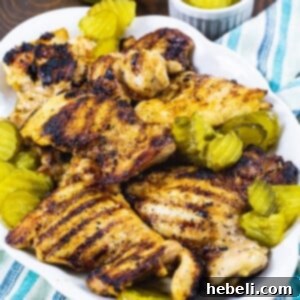 Pickle-Brined Grilled Chicken on a serving platter with pickle chips.
