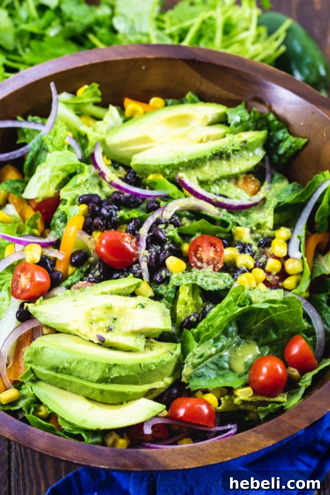 Serving of Southwestern Salad with Jalapeno Lime Vinaigrette in a smaller wooden bowl.