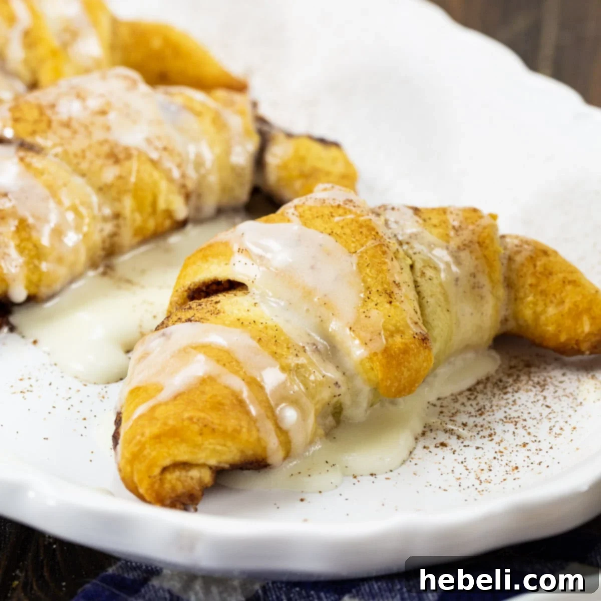 Glazed Cinnamon Roll Crescents Delicious Cinnamon Roll Crescents covered in a sweet white glaze, ready to be served.