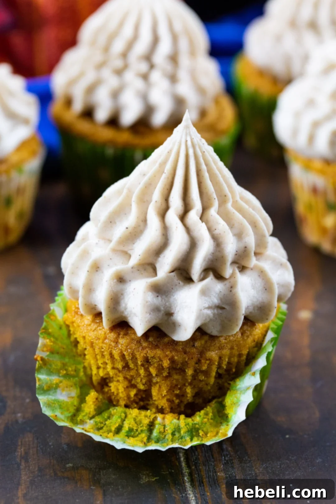 Close-up of a perfectly frosted Pumpkin Cupcake, showcasing its moist texture.