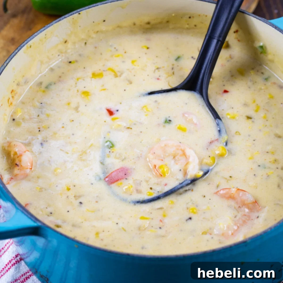 Rich and creamy Southwestern Shrimp Chowder in a rustic Dutch oven, garnished with fresh cilantro and a lime wedge, ready to be served.
