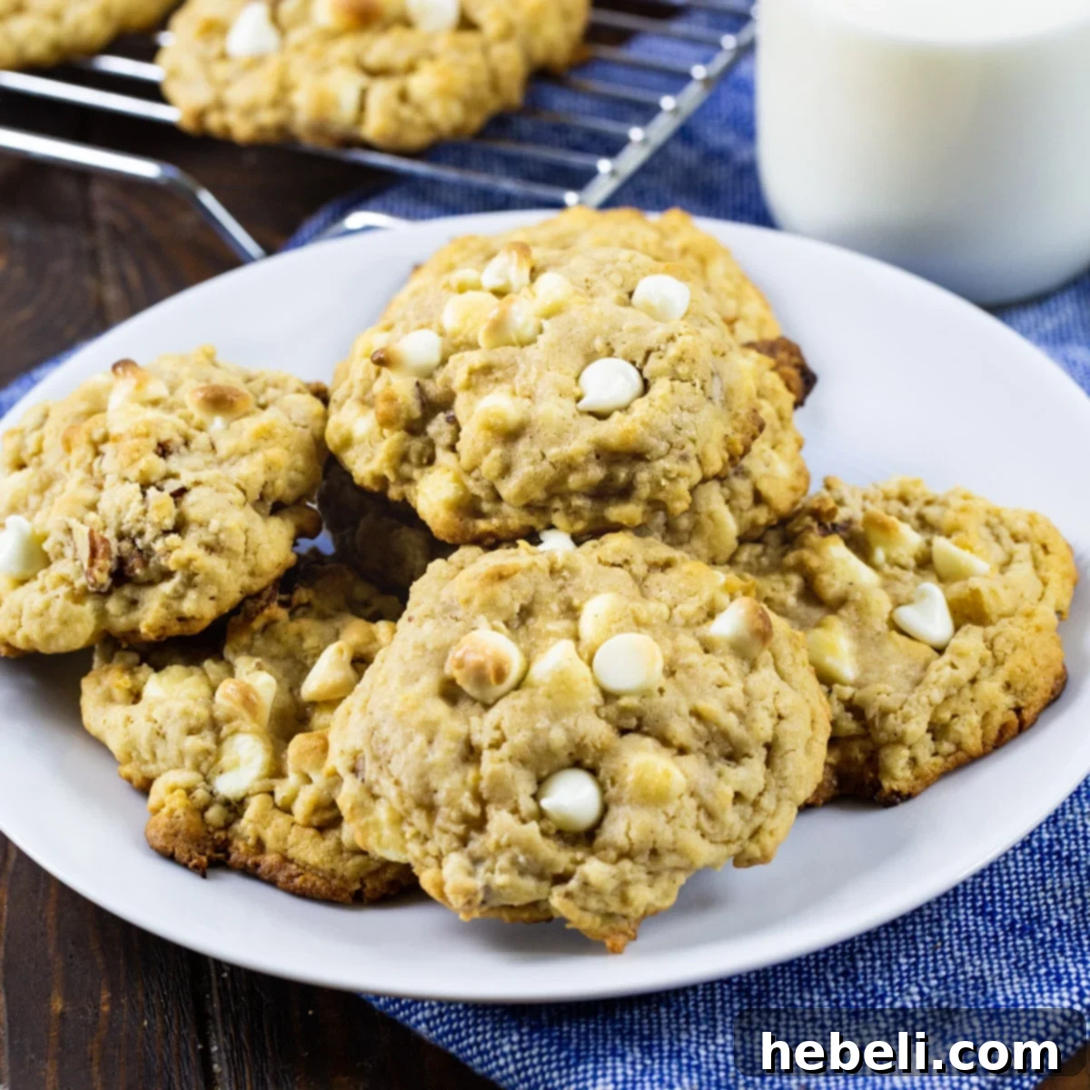 White Chocolate Oatmeal Cookies with Pecans Delicious White Chocolate Oatmeal Cookies on a pristine white plate, showcasing their soft, chewy texture and visible white chocolate chips and pecans.