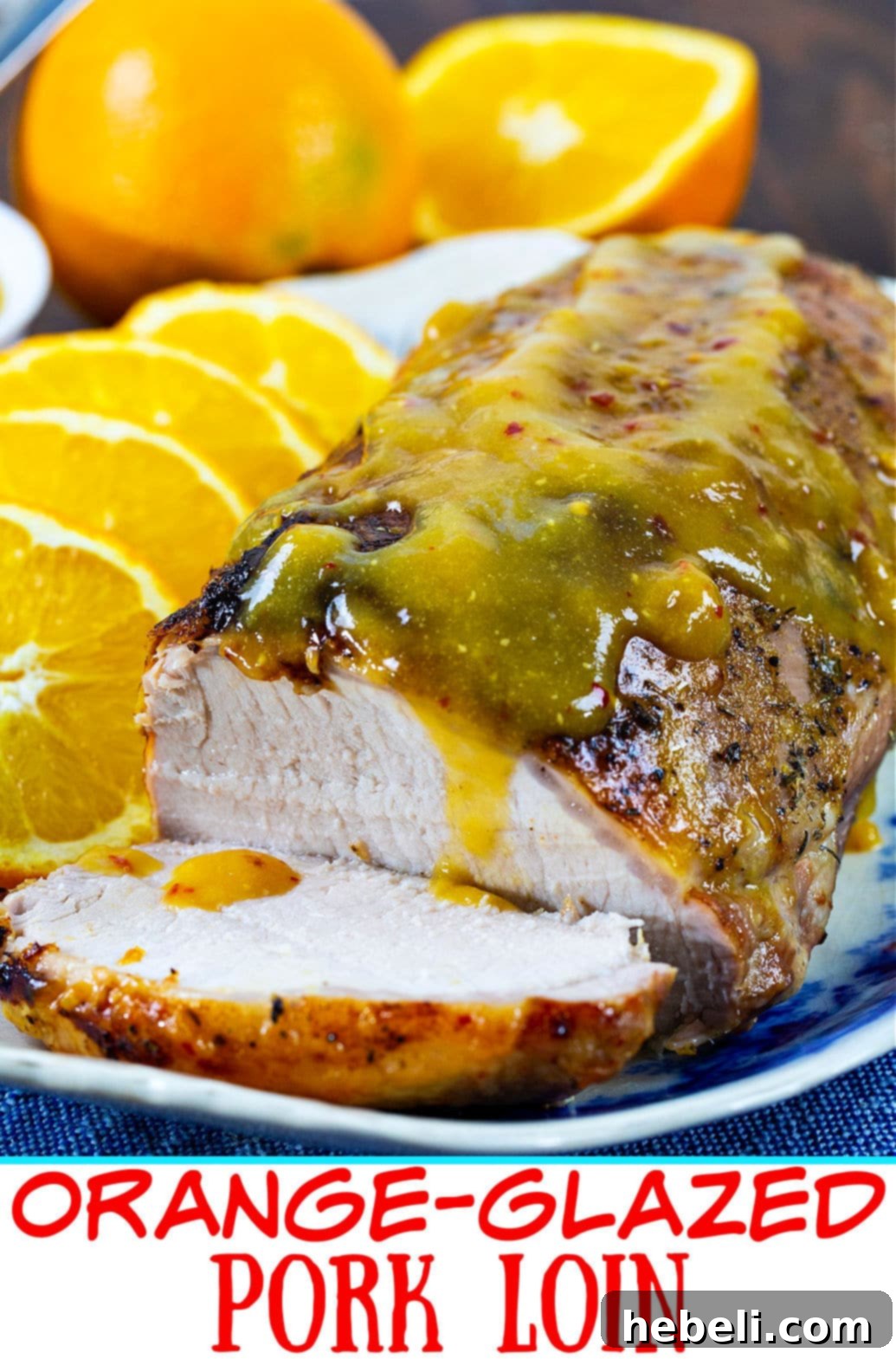 Slices of Orange-Glazed Pork Loin arranged on a plate with extra glaze, showcasing its tenderness and appetizing appearance.