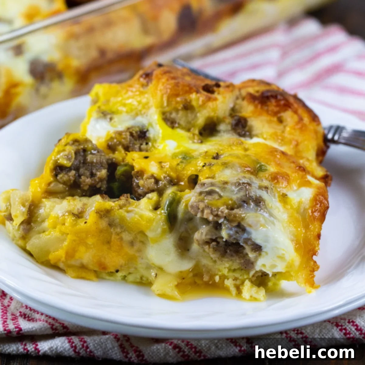 A perfectly sliced portion of Breakfast Biscuit Bubble Up Casserole on a plate, showcasing the layers of sausage, cheese, eggs, and golden-brown biscuits.