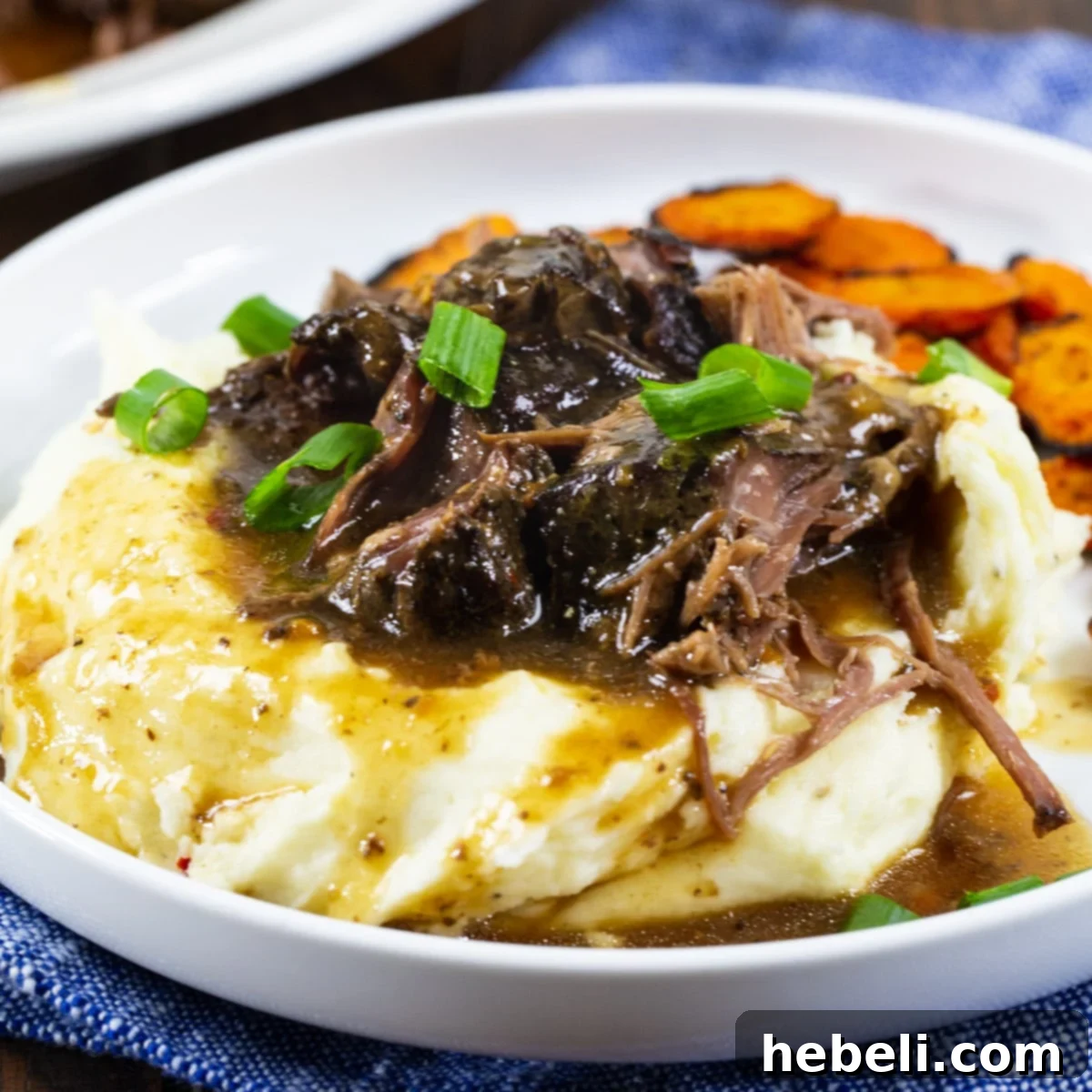 3-Packet Slow Cooker Pot Roast 2 Slow Cooker 3-Packet Pot Roast over creamy mashed potatoes, ready to be served for a comforting meal.
