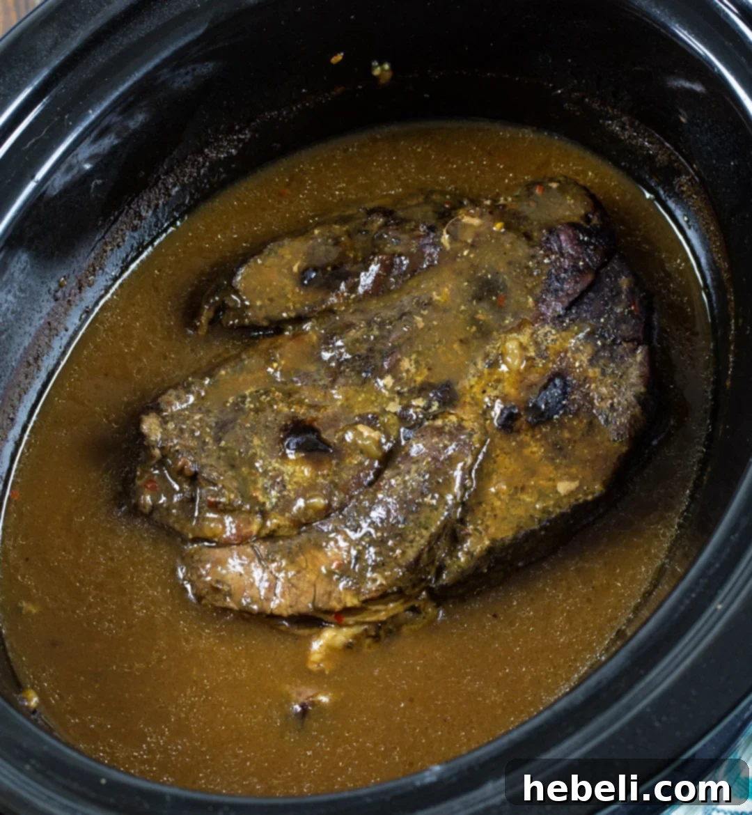 3-Packet Slow Cooker Pot Roast 3 A perfectly cooked Slow Cooker 3-Packet Pot Roast resting in the slow cooker, surrounded by rich gravy.