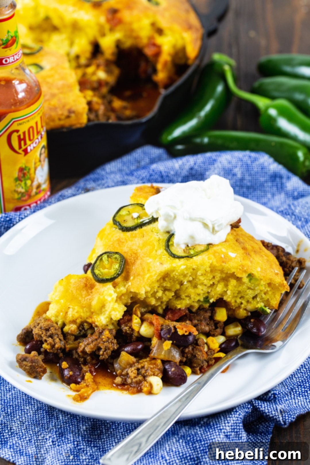 A close-up shot of a slice of the hearty cornbread casserole on a plate, highlighting the rich chili base and golden cornbread top.