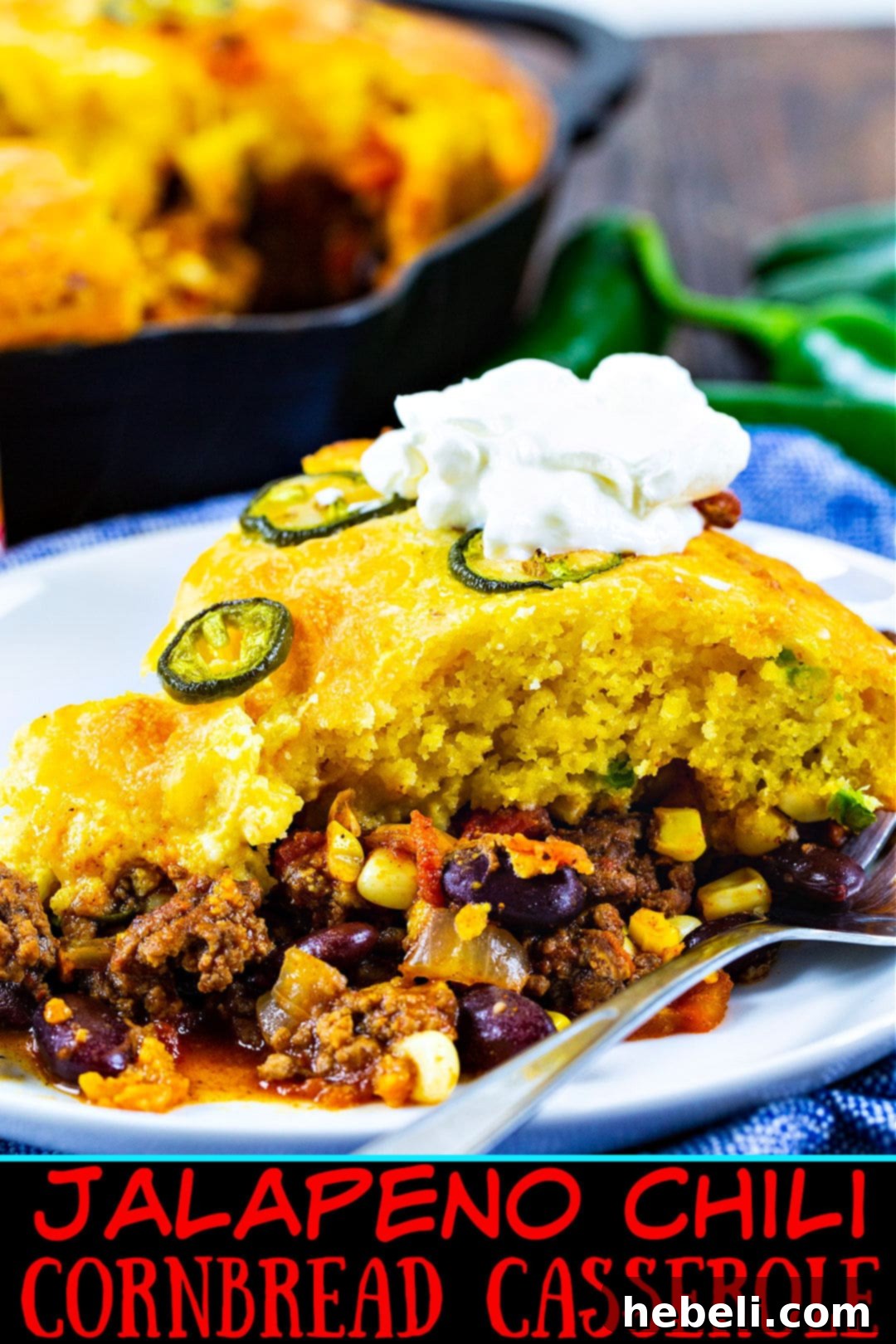 Jalapeno Chili Cornbread Casserole topped generously with cool sour cream, ready to be enjoyed.