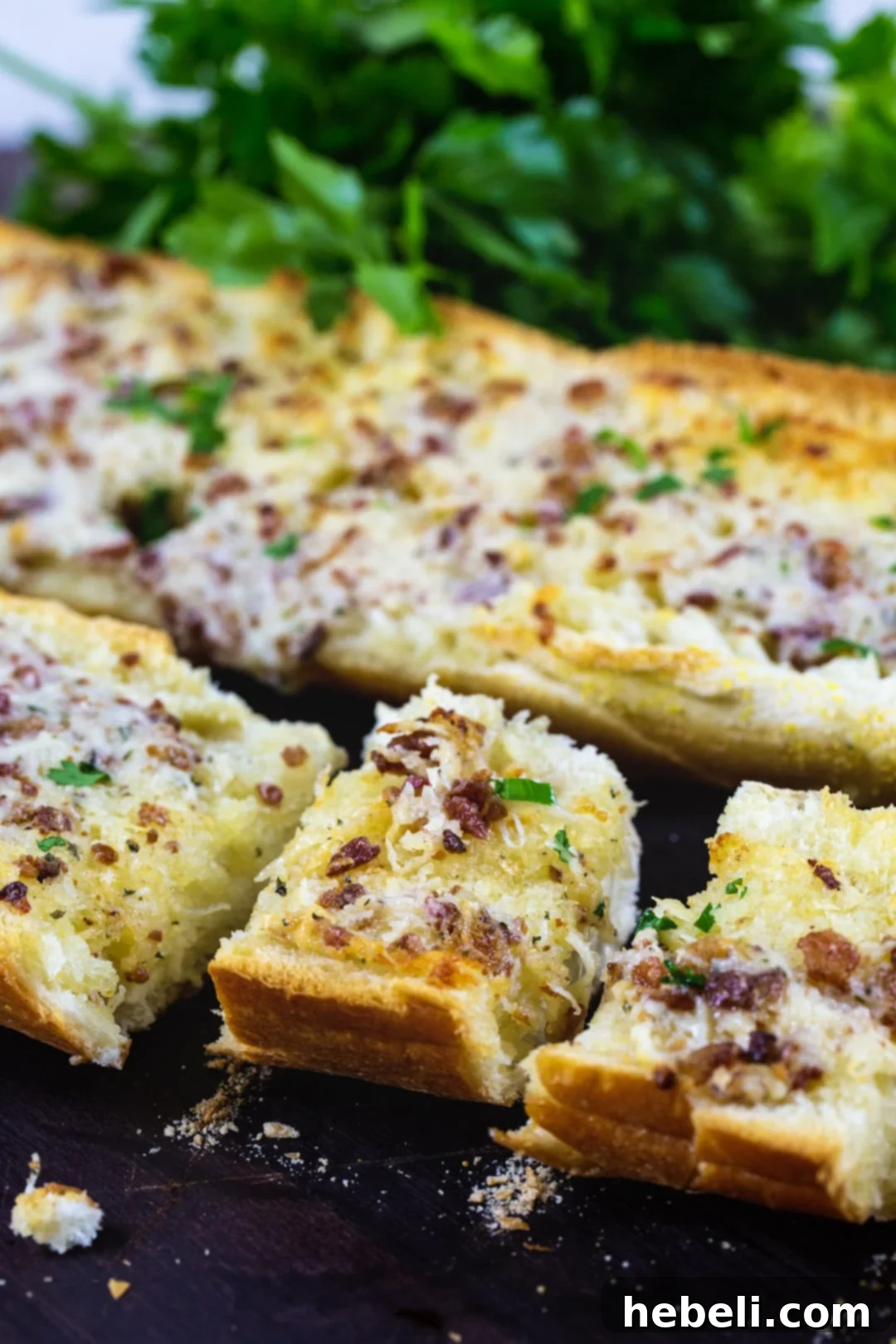 Garlic bread cut into individual slices on a cutting board, ready to be served.