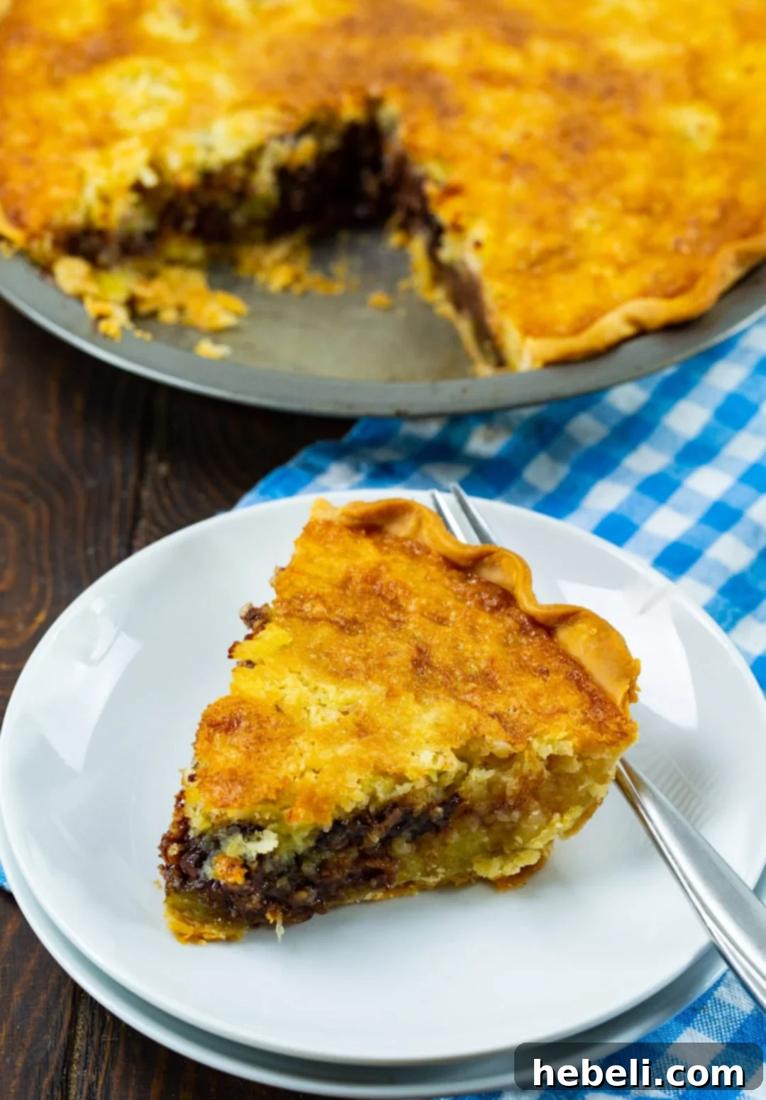 Creamy Coconut Buttermilk Bliss 3 A half-eaten slice of Coconut Buttermilk Pie on a white plate, with the rest of the pie visible in the background. The rich, golden custard and visible coconut flakes are tempting.