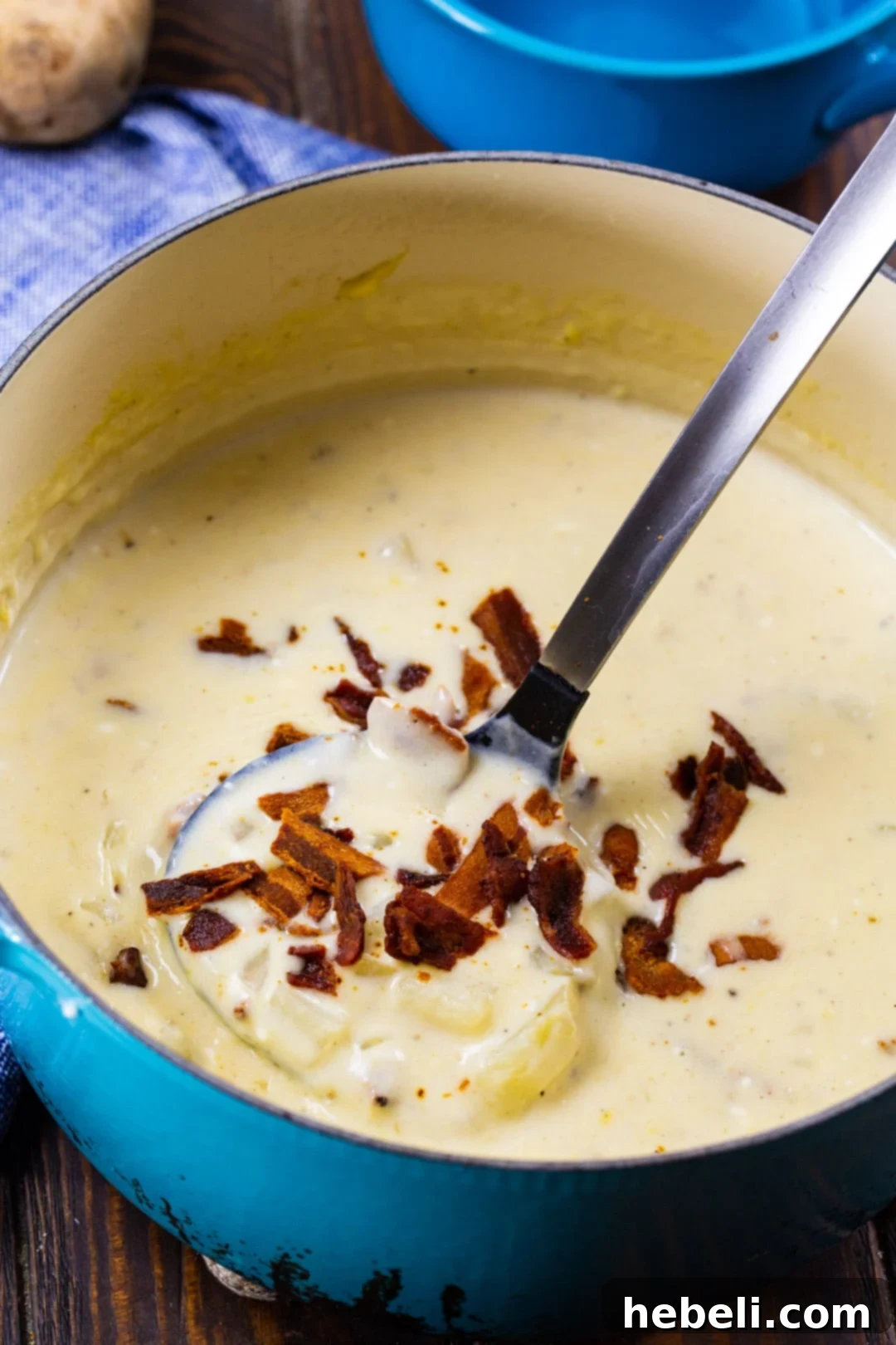 Loaded Bacon Potato Soup 3 Easy Bacon and Potato Soup simmering gently in a rustic red Dutch oven, showcasing its creamy texture and chunky ingredients, with steam rising invitingly.