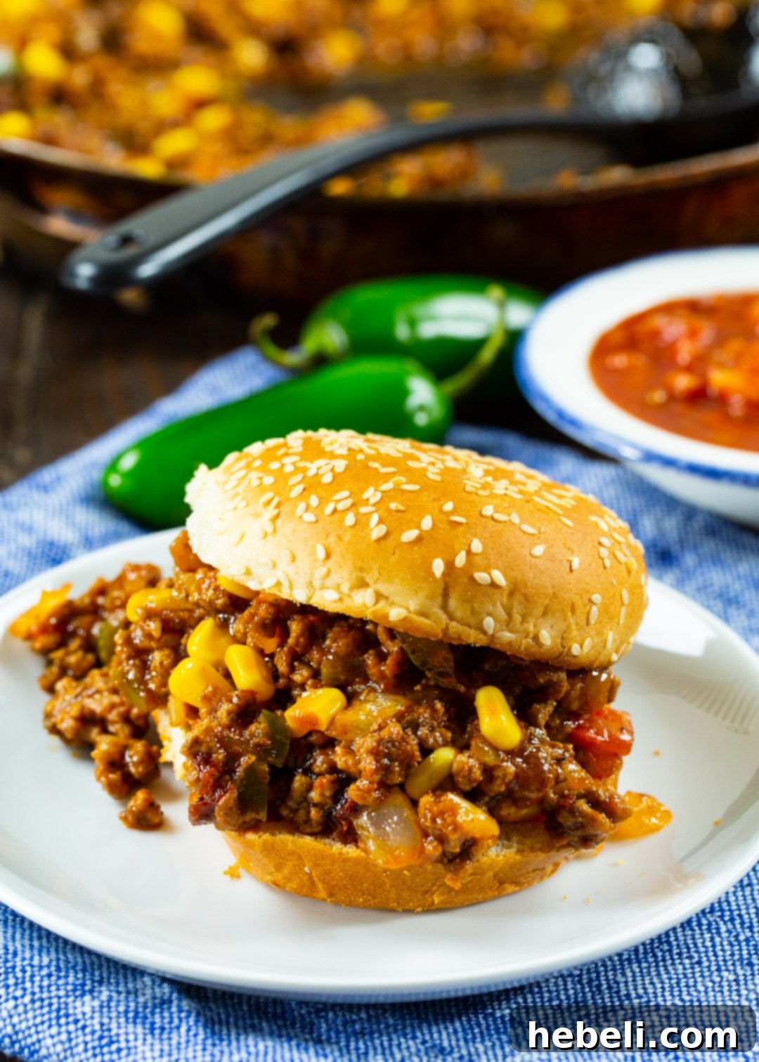Two Tex-Mex Sloppy Joes served on toasted buns with a side of golden tortilla chips.