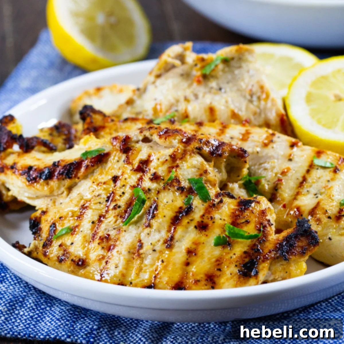 Grilled Italian Dressing Chicken served on a plate with fresh lemon slices and herbs, highlighting its golden-brown color and juicy appearance.