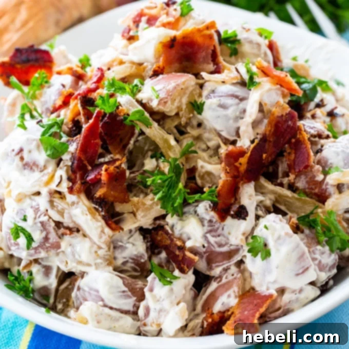Savory Onion Potato Delight 2 Caramelized Onion Potato Salad topped with crumbled bacon in a serving bowl, showcasing its rich texture and delicious ingredients.