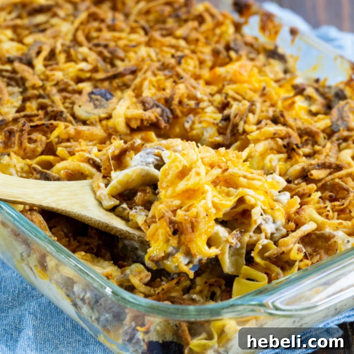 A golden-brown French Onion Beef Casserole in a baking dish, fresh from the oven, topped with melted cheese and crispy onions.