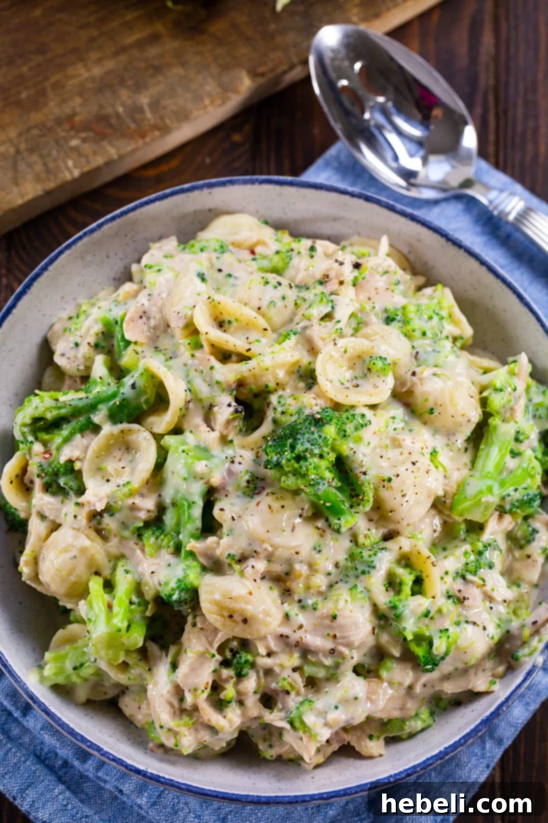 Hearty Turkey Broccoli Alfredo 3 A close-up of creamy Alfredo pasta in a rustic blue and white serving bowl, highlighting the texture and richness of the sauce.