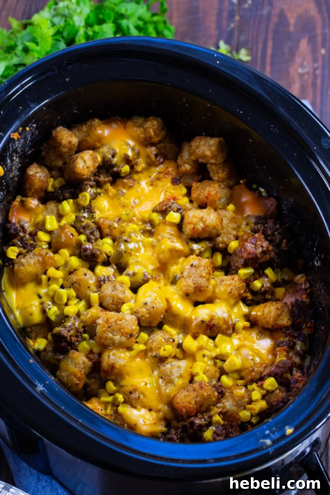 Taco Casserole in a slow cooker, showing the layers of ingredients before cooking.