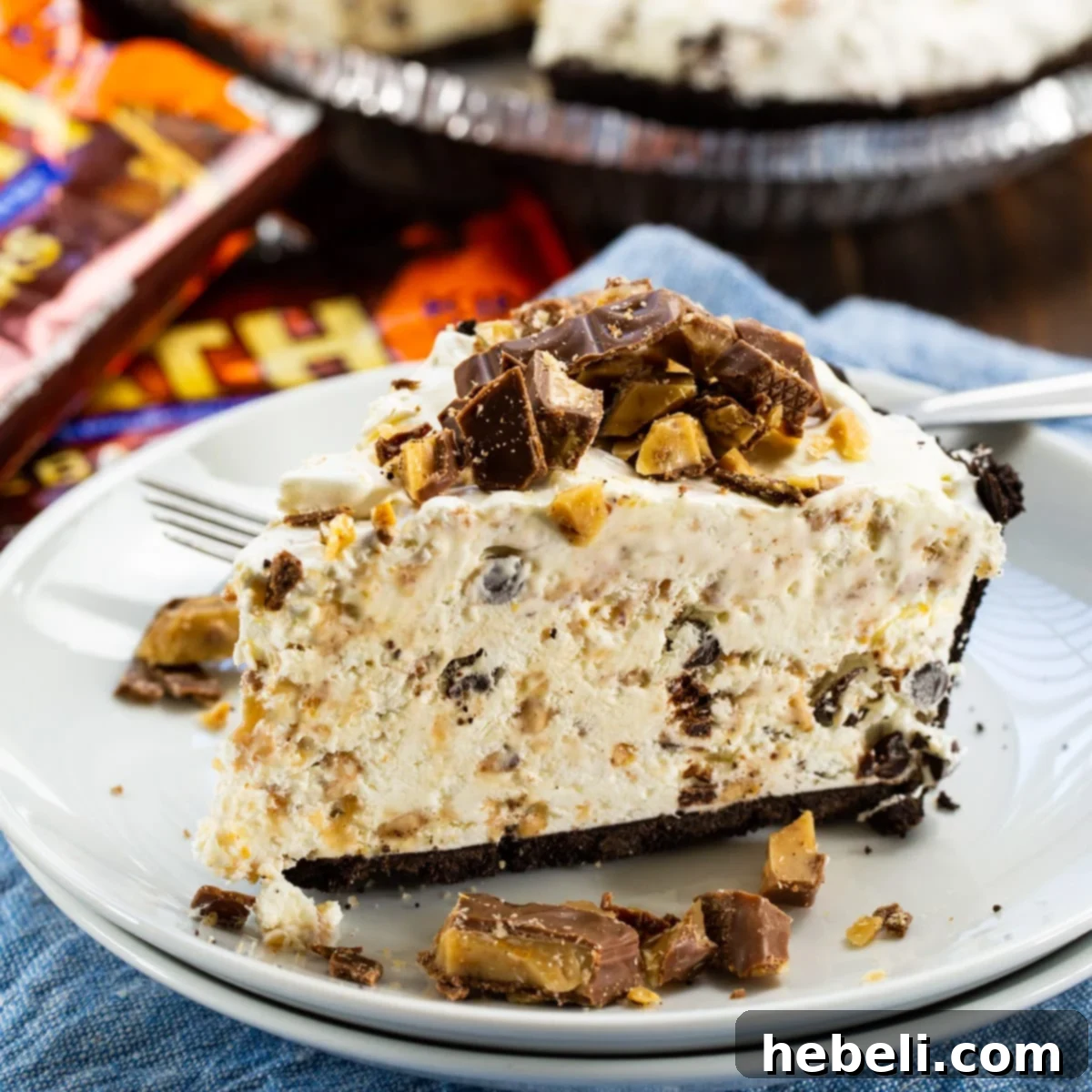 A pristine slice of Frozen Toffee Pie on a white plate, showcasing its luscious layers and crunchy Oreo crust, ready to be enjoyed.