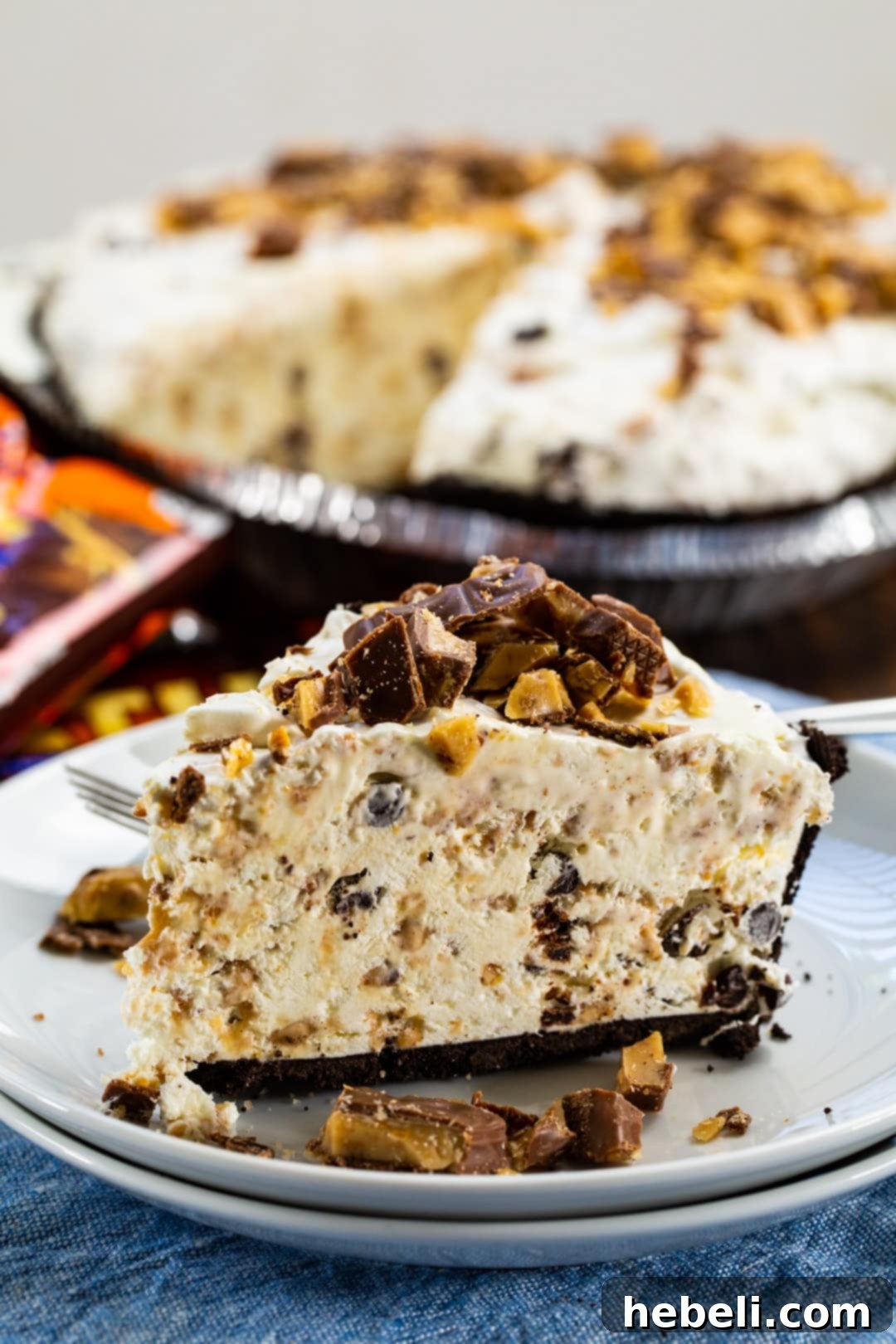 A close-up view of a scrumptious slice of Frozen Toffee Pie, generously topped with crunchy chopped Heath bars, highlighting its appealing texture.