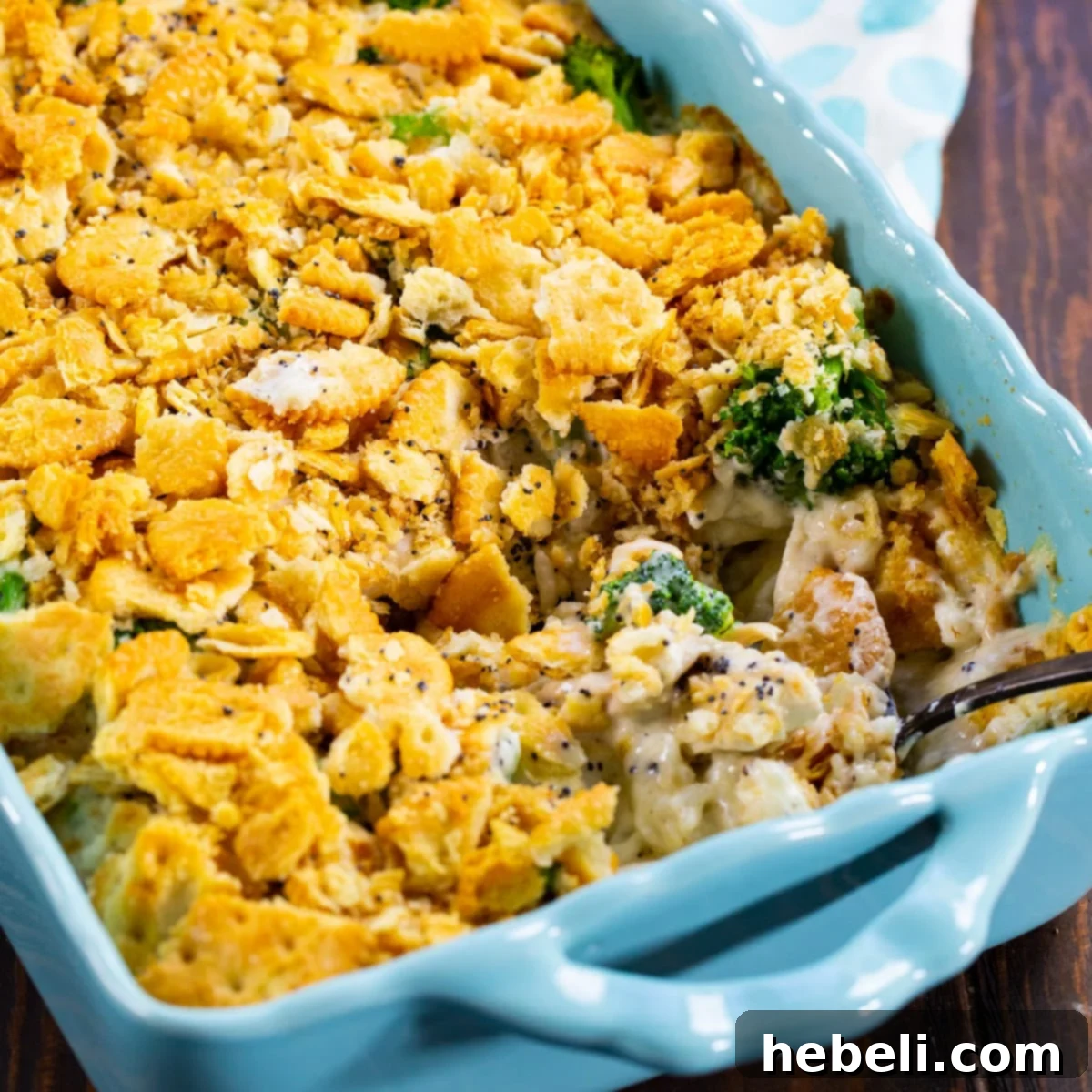 Chicken Broccoli Poppy Seed Casserole in blue baking dish, garnished with fresh herbs.