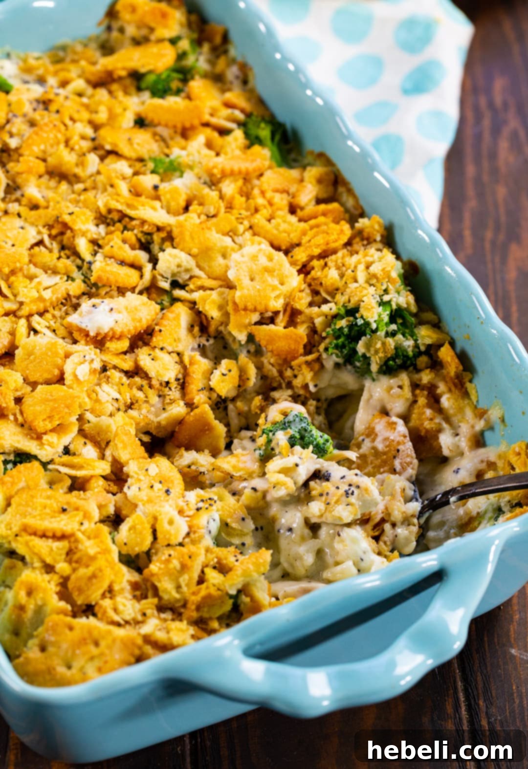 Close-up of Chicken Broccoli Poppy Seed Casserole in baking dish with serving spoon.