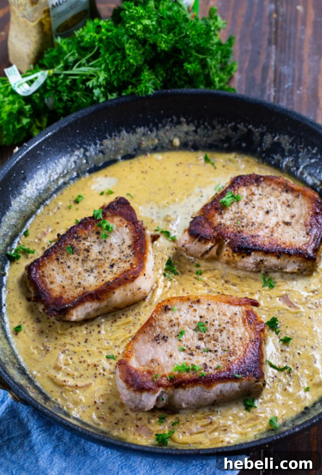 Pork Chops searing beautifully in a hot skillet, developing a golden-brown crust.