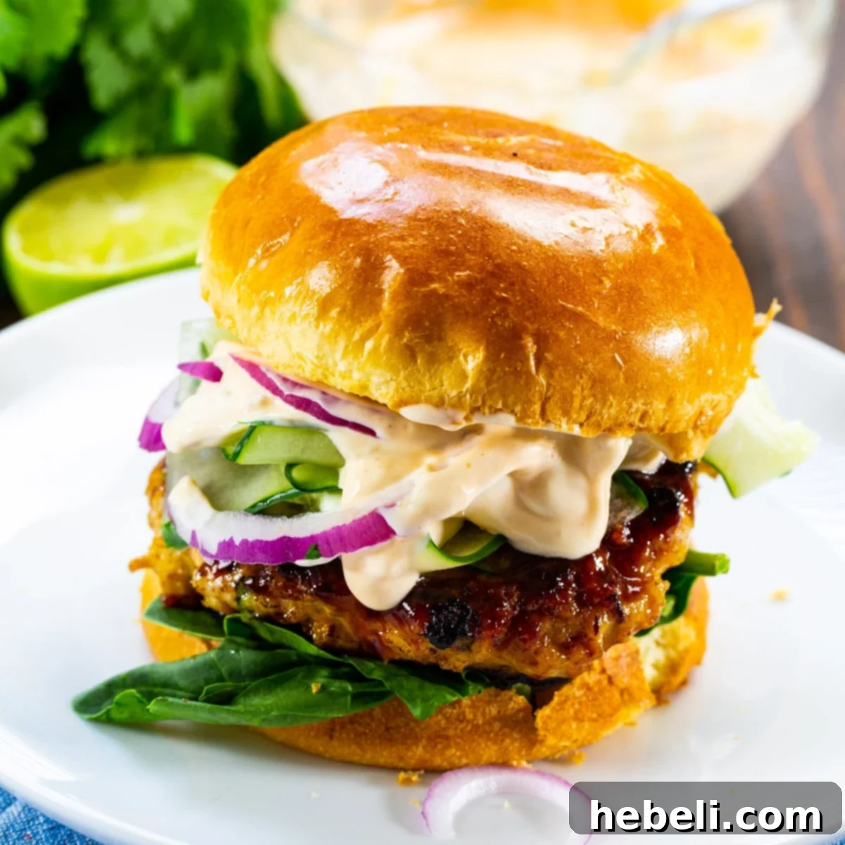 Teriyaki Chicken Burgers 2 Two perfectly cooked Teriyaki Chicken Burgers on a plate, garnished with fresh herbs and a side of ginger mayonnaise.