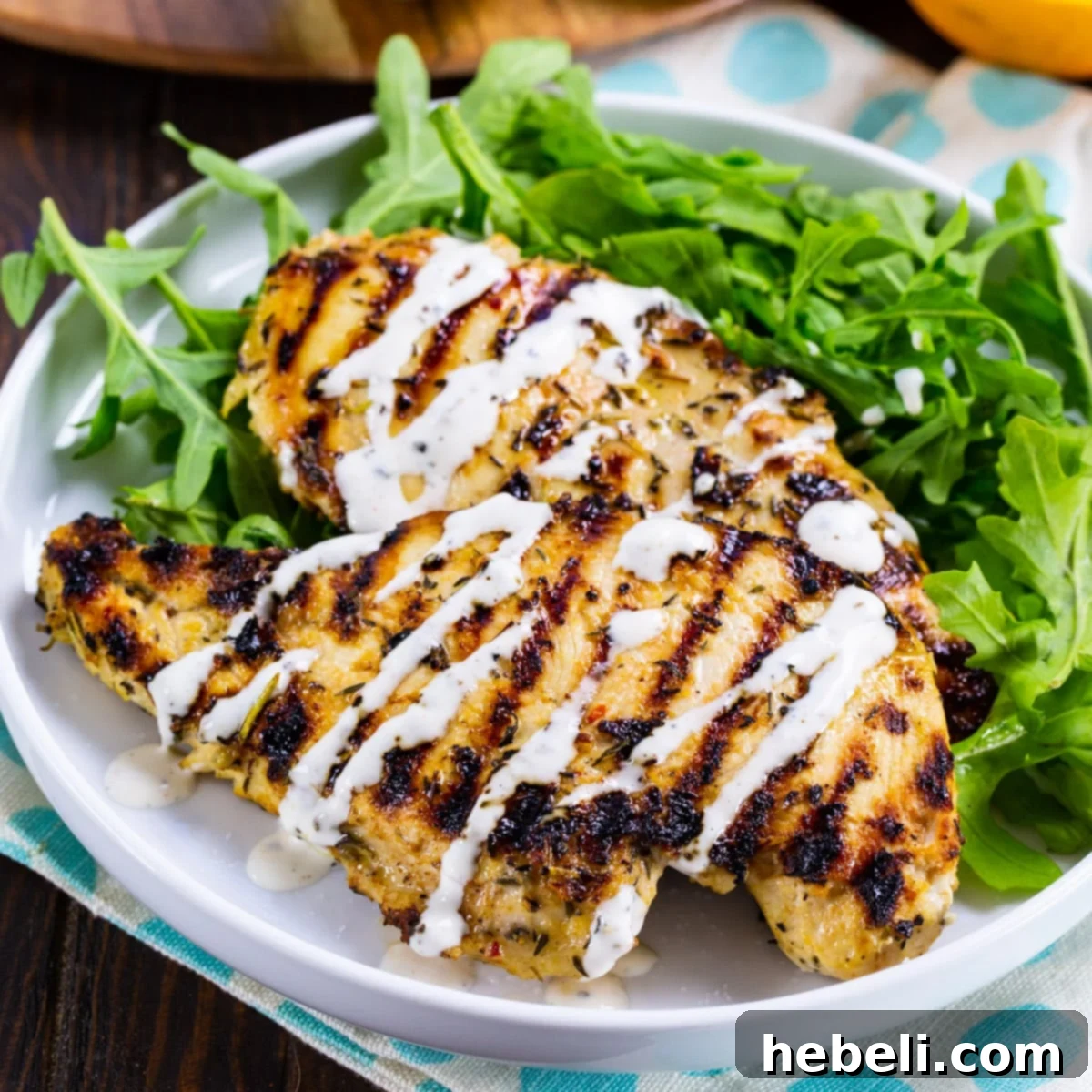 Sun-Kissed Grilled Chicken 2 Perfectly grilled citrus chicken on a plate, served with a fresh green salad.