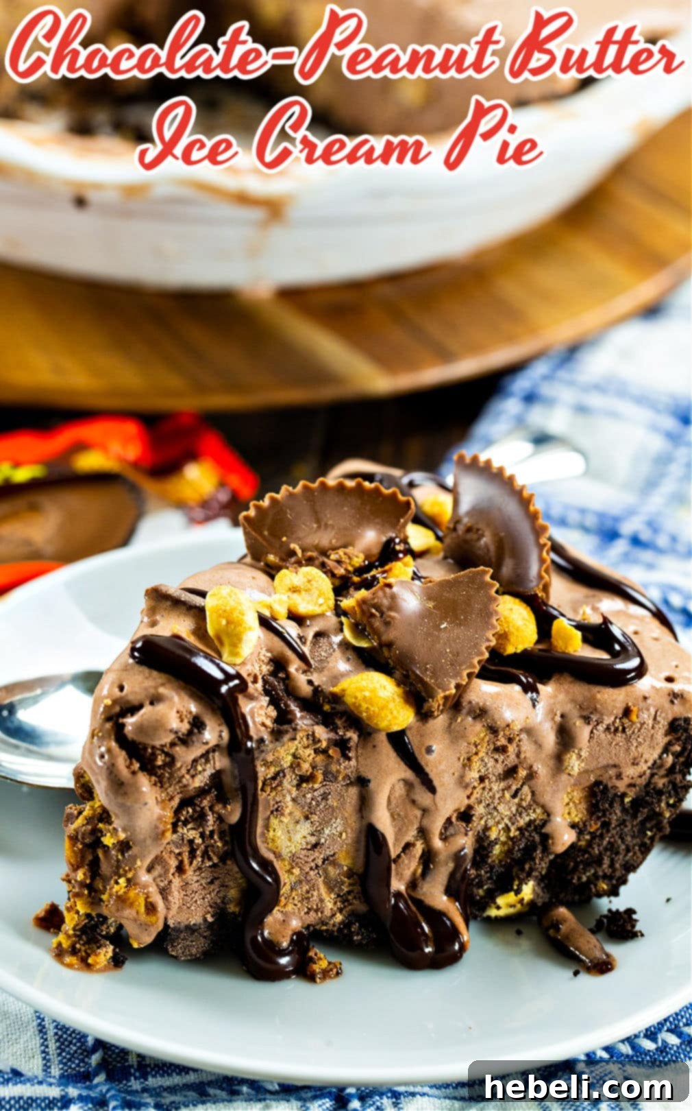 A slice of Chocolate Peanut Butter Ice Cream Pie beautifully presented on a plate, generously drizzled with rich fudge sauce and garnished with chopped peanuts and peanut butter cup pieces.