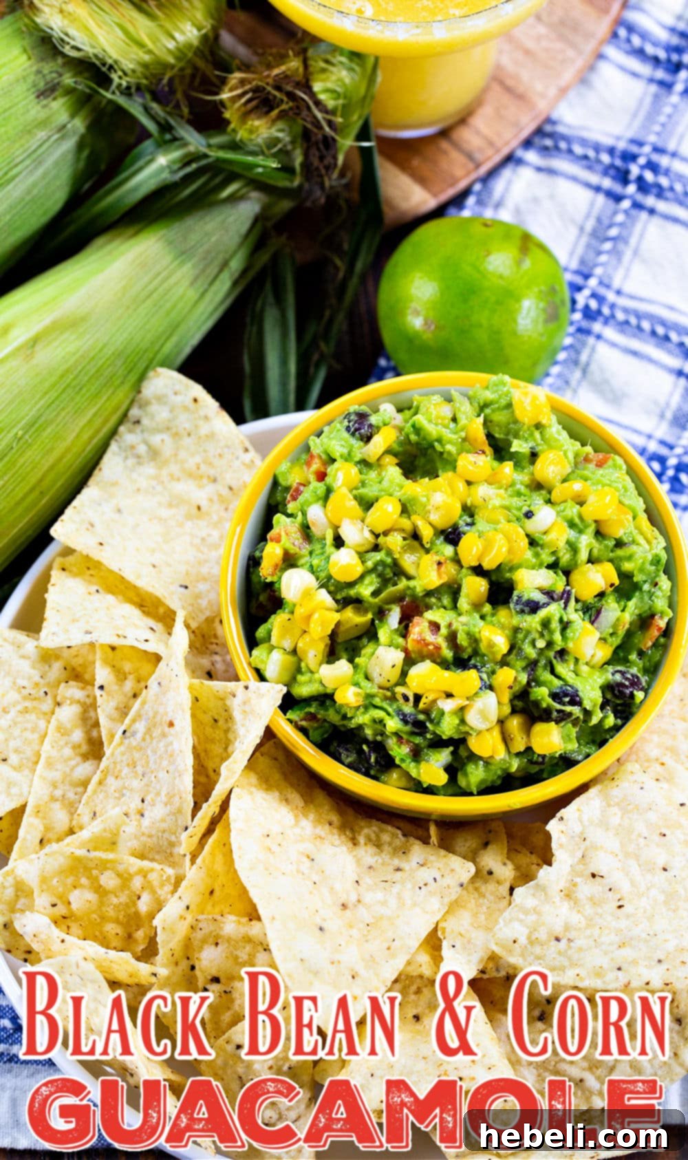 A close-up shot of creamy Black Bean and Corn Guacamole in a bowl, surrounded by crispy tortilla chips, ready for dipping.