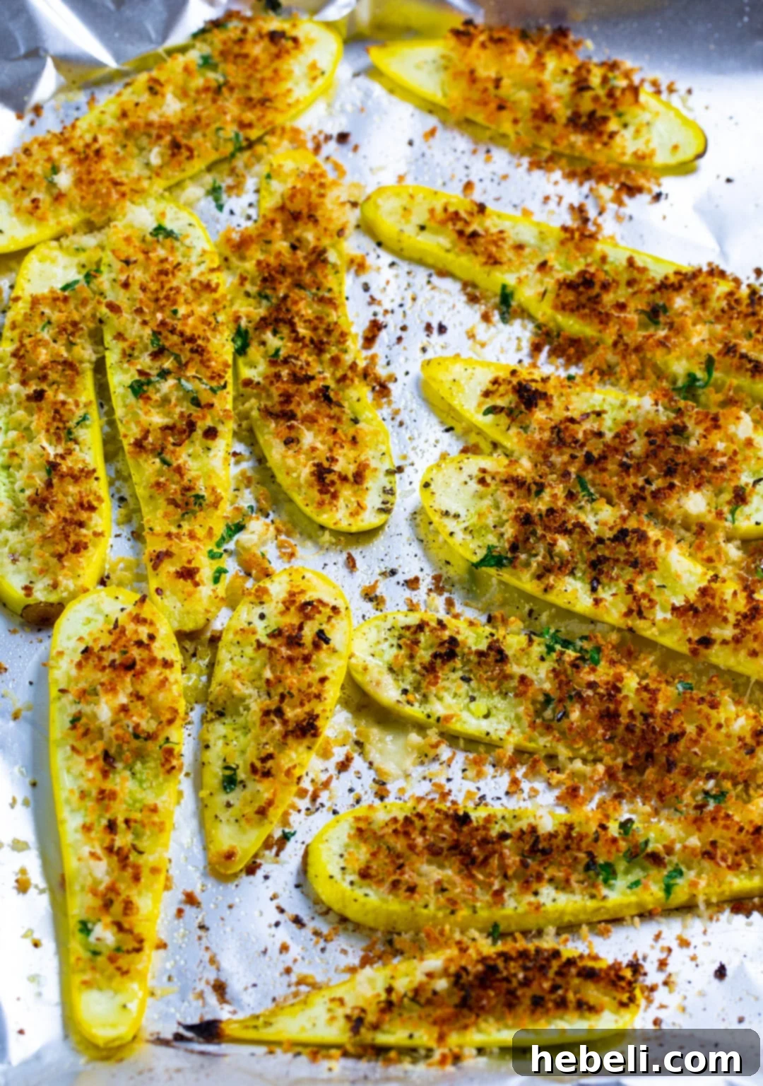 Crispy Panko Parmesan Squash Fries 4 Baked squash slices evenly topped with the Panko Parmesan and garlic mixture on a baking sheet, ready for broiling.