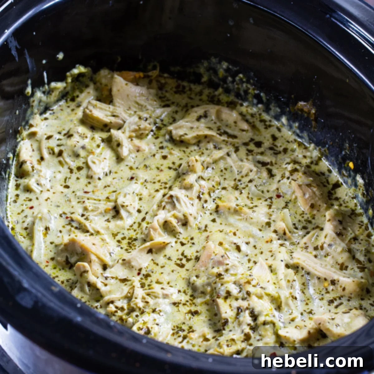 Creamy Pesto Chicken in black slow cooker.