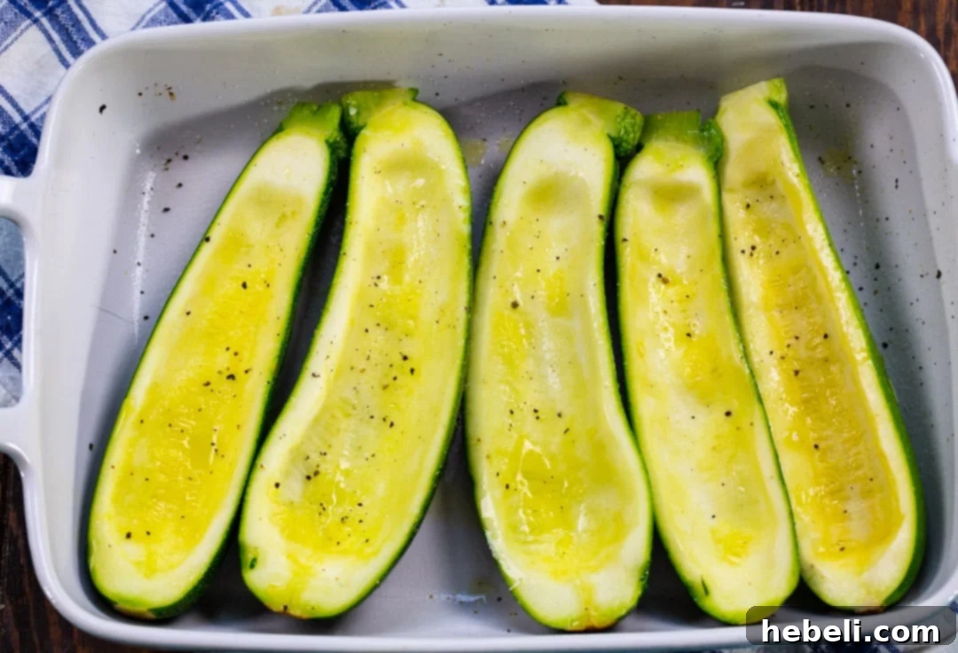Hollowed out zucchini halves, lightly coated with olive oil and seasoned, pre-baked in a glass baking dish until slightly softened.