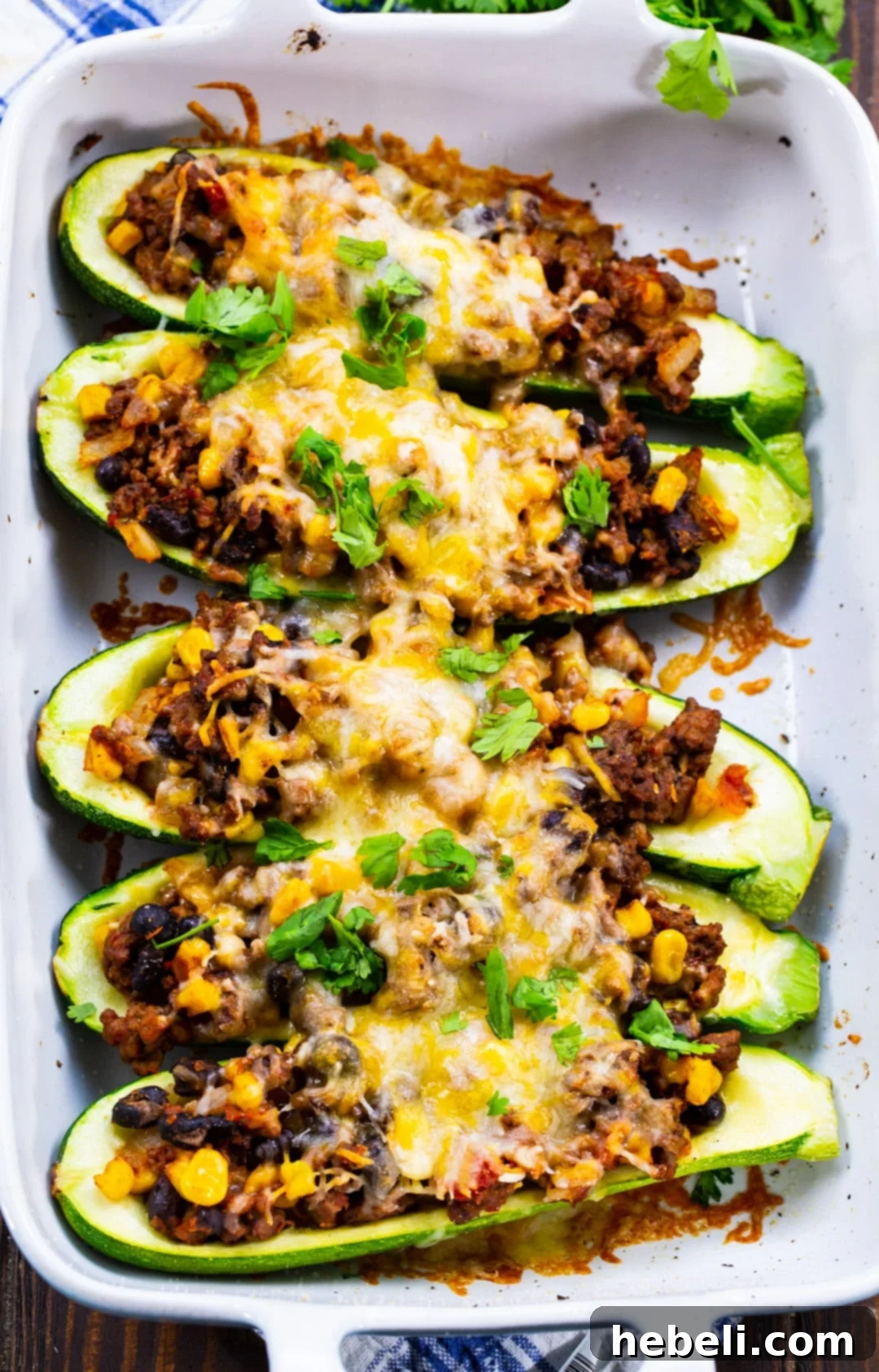 The fully baked and finished Taco Zucchini Boats with melted, golden-brown cheese, presented beautifully in a baking dish.