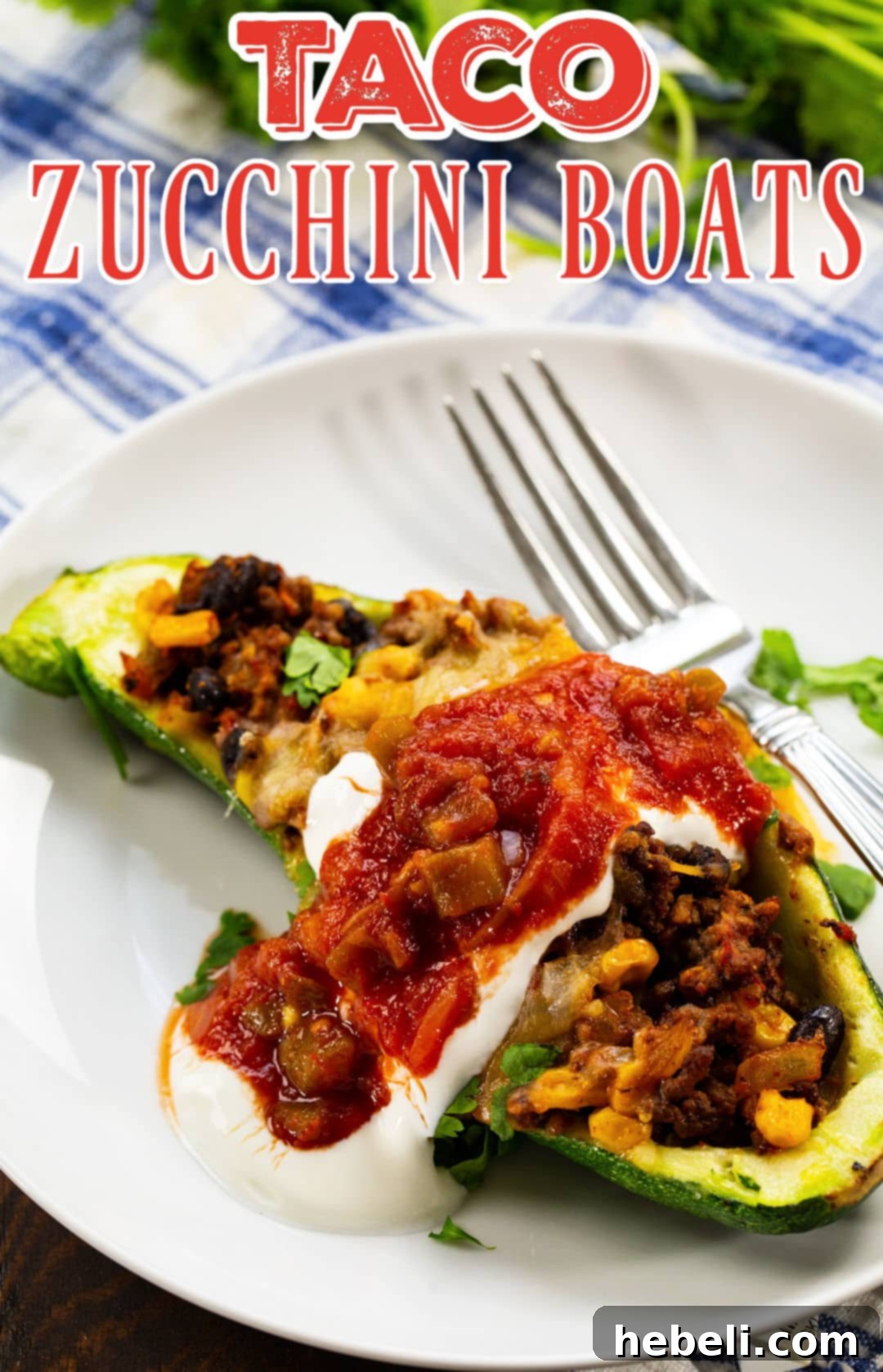 A single Taco Zucchini Boat, beautifully garnished with a dollop of sour cream, fresh salsa, and cilantro, served on a white plate.