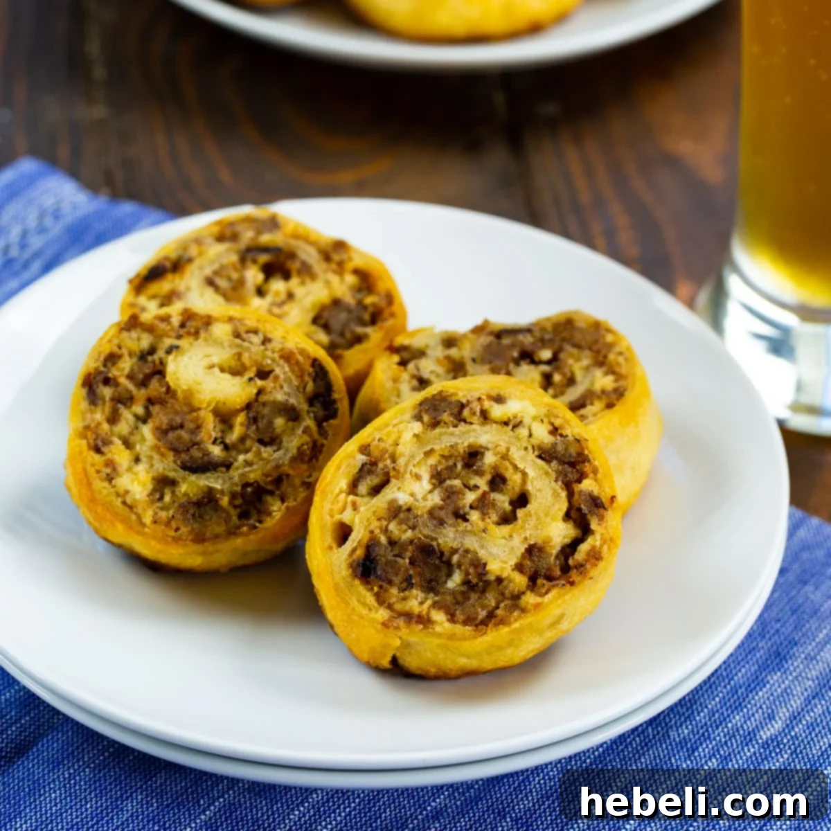 Perfectly baked golden-brown Sausage Cream Cheese Pinwheels arranged on a serving plate, ready to be enjoyed.