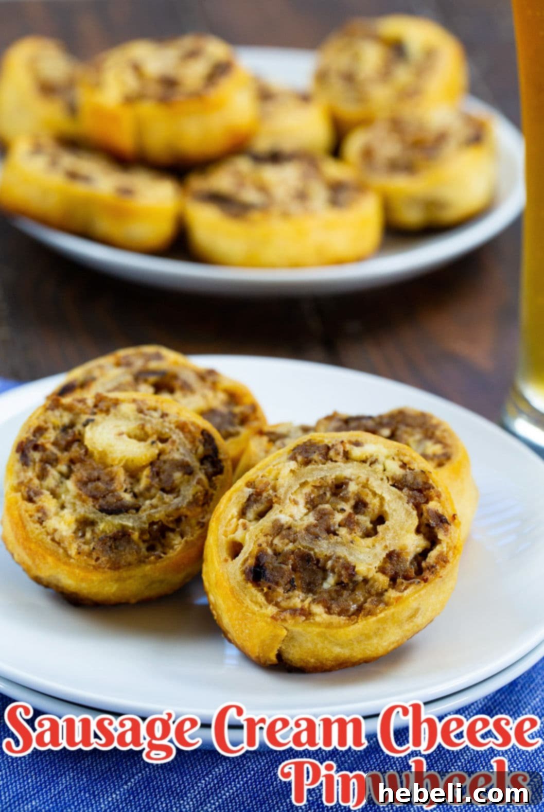A close-up shot of several Sausage Cream Cheese Pinwheels, perfectly golden-brown and flaky, displayed on a plate.